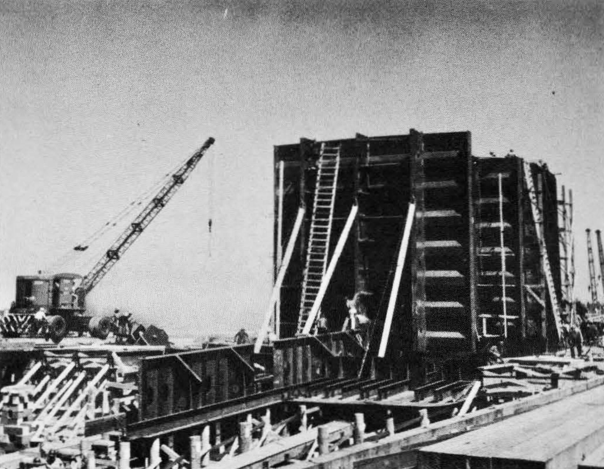 Black and white photograph of cargo tank bulkheads for the SS Schenectady being brought into place at the Swan Island shipyards.